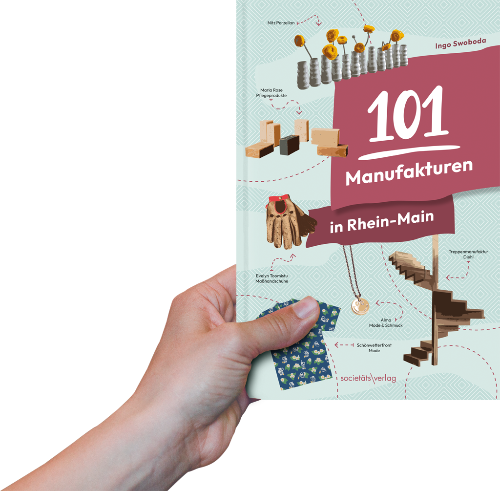 Foto: Eine Hand hält das Buch "101 Manufakturen in Rhein-Main" hoch