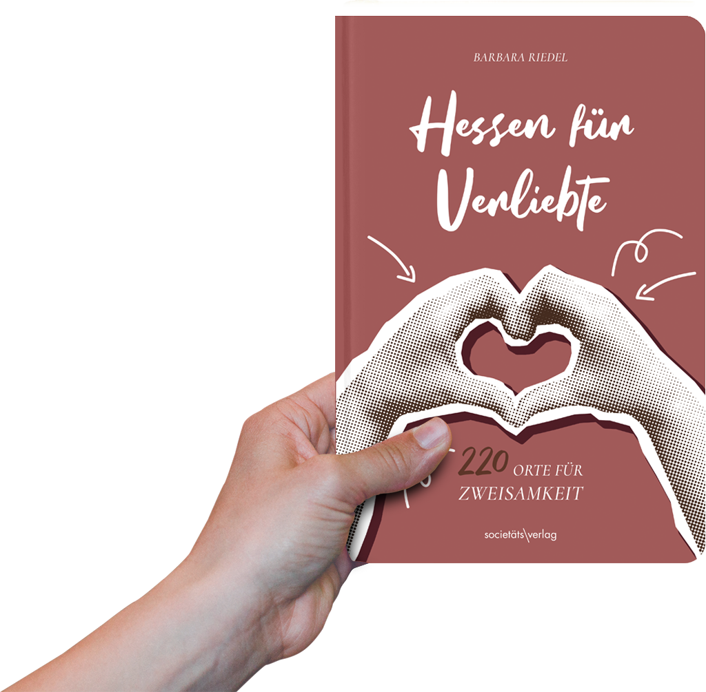 Foto: Eine Hand hält das Buch "Hessen für Verliebte" hoch