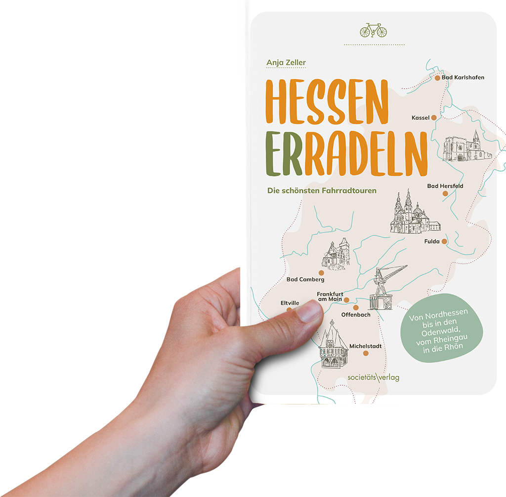 Foto: Eine Hand hält das Buch "Hessen erradeln" hoch