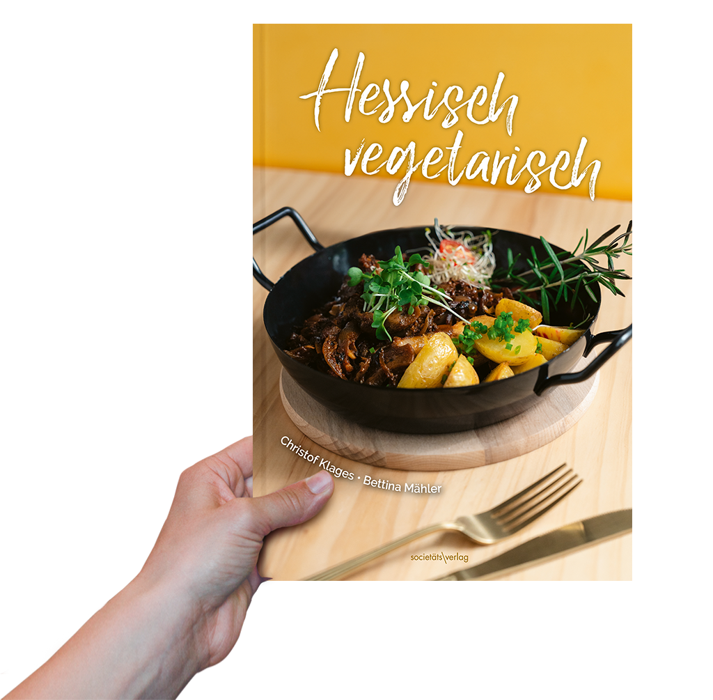 Foto: Eine Hand hält das Buch "Hessisch vegetarisch" hoch